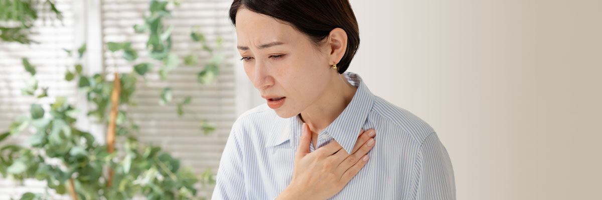 胸を押さえる女性