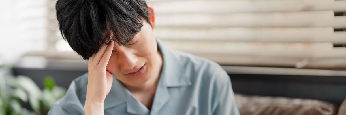 頭を押さえる男性